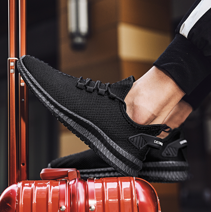 Running Shoes Sneakers Casual Men's Outdoor Athletic Jogging Sports in black color on a travel suitcase.