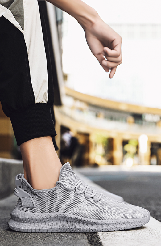Running Shoes Sneakers Casual Men's Outdoor Athletic Jogging Sports in light gray color on urban sidewalk.