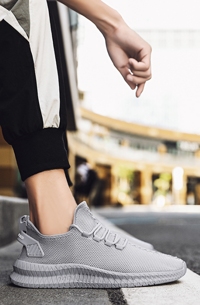 Running Shoes Sneakers Casual Men's Outdoor Athletic Jogging Sports in light gray color on urban sidewalk.