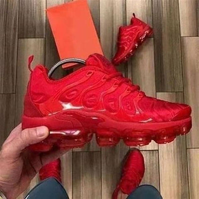 : A bold all-red athletic sneaker with a wavy design on the upper, featuring a fully red transparent air-cushioned sole.