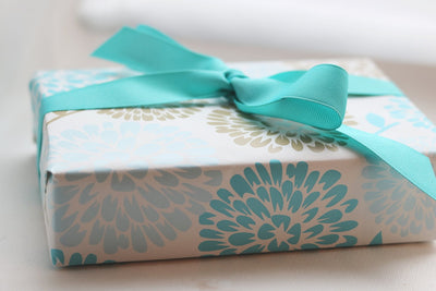 Soap Sampler Gift Set beautifully wrapped in floral paper with a turquoise ribbon, perfect for gifting.