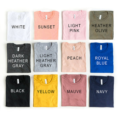 Variety of colorful t-shirts including the Be Kind T-shirt in different sizes and colors.