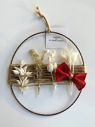 Dried Flower Christmas Wreath Christmas Decoration featuring dried flowers and a red bow on a jute-wrapped metal ring.
