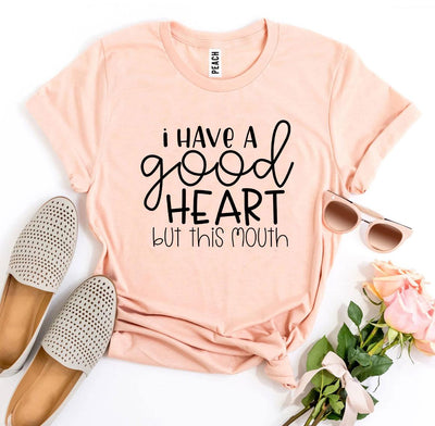 I Have a Good Heart But This Mouth T-shirt in peach color with casual accessories like sunglasses and shoes.