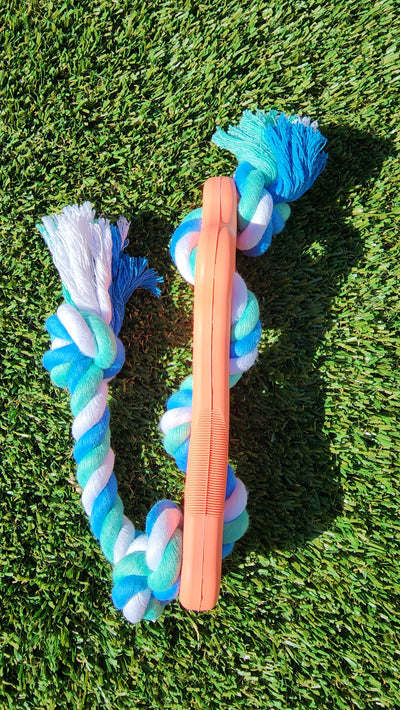 Rubber Bone Dog Chew Toy with Tug Rope -- Great for Active Dogs on green grass background.