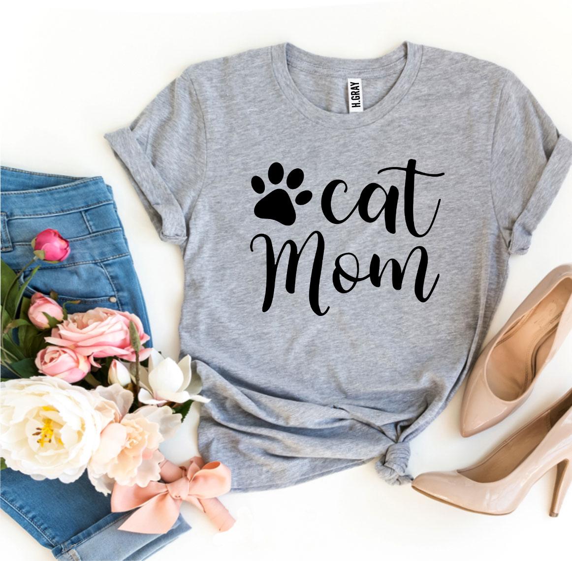 Cat Mom T-shirt displayed with flowers and a stylish outfit for cat lovers.