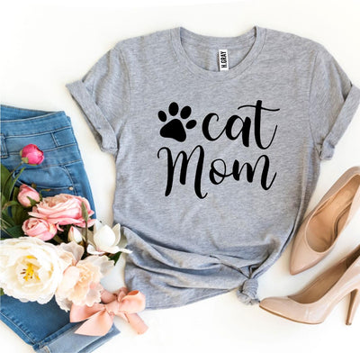 Cat Mom T-shirt displayed with flowers and a stylish outfit for cat lovers.